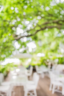 Arka plan kullanımı için yeşil ağaç bokeh ile gündüz vakti bulanık bir restoran görüntüsü .