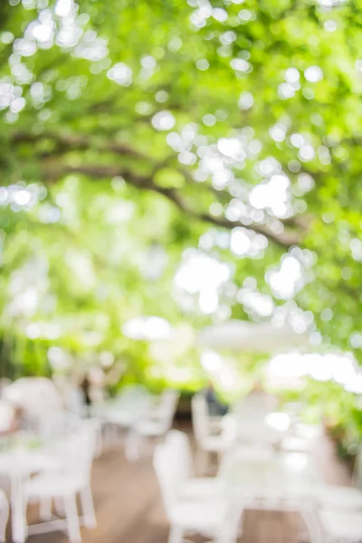 image of blur outdoor restaurant on day time with green tree bokeh for background usage .