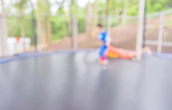 Afbeelding van jong geitje in trampoline springen vervagen. — Stockfoto