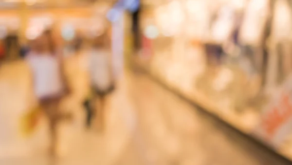 ショッピング モールを歩く人々 のぼやけた画像がボケ味を持つ背景をぼかし. — ストック写真
