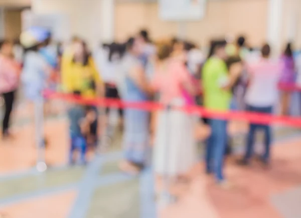 blur image of people in queue in front of exhibition gate.