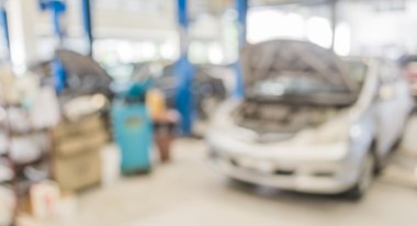 blur image of worker fixing car in ther garage. clipart