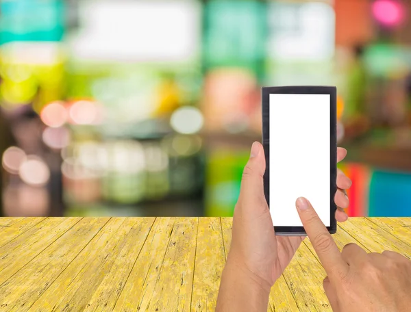 Mano masculina está sosteniendo un teléfono de pantalla táctil moderna y cafetería — Foto de Stock