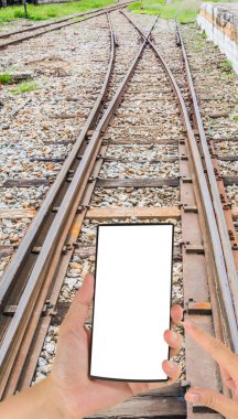 Erkek el görüntüsünü bir modern dokunmatik ekran telefon ve demiryolu hatları tutuyor