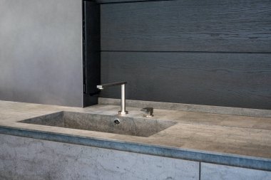 Koyu bej mermer leğen ve parlak metal karıştırıcı.