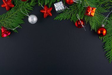 Noel kompozisyonu. Siyah arka planda firavun ağacı, gümüş ve kırmızı süsler. Düz konum, üst görünüm, kopyalama alanı. 