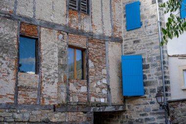 Küçük bir Fransız kırsalındaki taş antik binadaki eski mavi pencereler. Fransa 'nın eski Saint-Antonin-Noble-Val kasabasındaki Picturesque caddesi. Yaz zamanı.