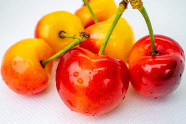 Beyaz arka planda kiraz. Kırmızı ve sarı dut yakın çekim makrosu. Arka plan bulanık. Organik meyve.