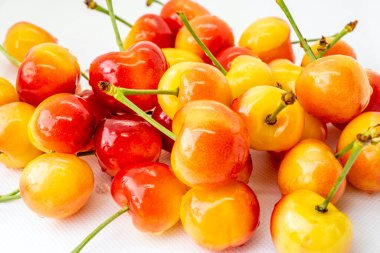 Beyaz arka planda kiraz. Kırmızı ve sarı dut yakın çekim makrosu. Arka plan bulanık. Organik meyve.