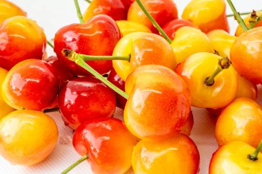 Beyaz arka planda kiraz. Kırmızı ve sarı dut yakın çekim makrosu. Arka plan bulanık. Organik meyve.