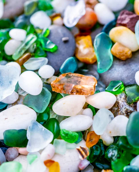 Colorful gemstones on a beach. Polish textured sea glass and