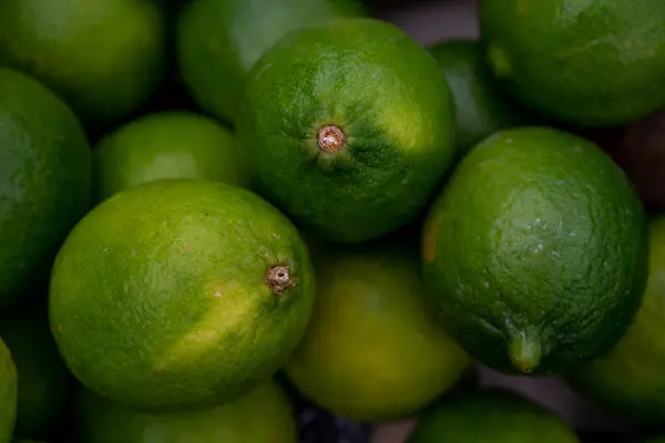 Limones verdes maduros frescos en el mercado. Textura de fondo, pila de cal. — Foto de Stock