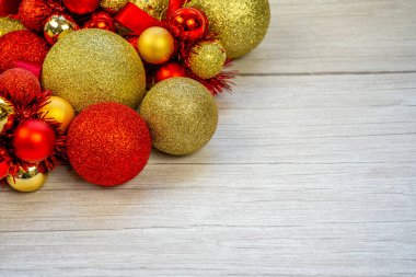 Beyaz ahşap arka planda altın ve kırmızı toplardan oluşan bir Noel sınırı. Yeni yıl tebrik kartı kopyalama alanı. Kaliteli fotoğraf