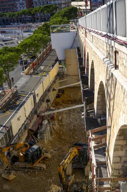 Monte-Carlo, Monaco 29.11.2020 İki tırtıl kazıcı gün içinde şantiyede çalışıyor. İş sahalarında kargo taşımak, kazmak ve taşımak için inşaat makineleri