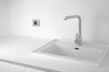 Lavabo ve krom musluklu modern banyo. Beyaz renk arkaplanı