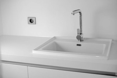 Lavabo ve krom musluklu modern banyo. Beyaz renk arkaplanı