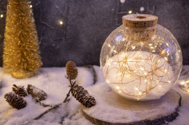 Karlı arka plan, çam kozalakları ve Noel ışığı. Kaliteli fotoğraf