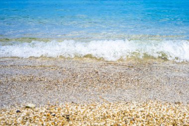 Güneşli bir günde açık mavi suyu ve kumlu plajı olan güzel bir deniz manzarası. Yüksek kalite fotoğraf
