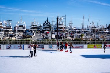 Monte Carlo, Monako - 14 Aralık 2020 İnsanlar Noel pazarında buz pateni yapıyor. Her kış şehir merkezindeki limanda geleneksel pazar.