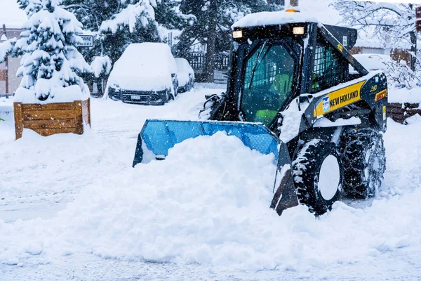 Auron, Fransa 01.01.2021 Yoğun bir kar yağışı altında bir kayak merkezinde kar temizleyen bir traktör. Dağ köyü — Stok fotoğraf