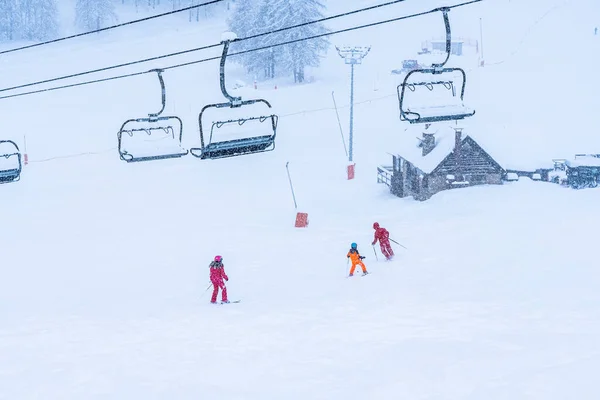 Auron, Frankrijk 01.01.2021 Snoeien op de skipistes. Lege stoel skilift. Scenic landschap. Kinderen skiërs rijden in de sneeuw achtergrond — Stockfoto