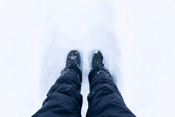 Χιονισμένες μπότες. Κάτοψη παπουτσιών ή μποτών σε φρέσκο χιόνι. Χειμερινή περίοδος. Εστίαση στα πόδια. — Φωτογραφία Αρχείου