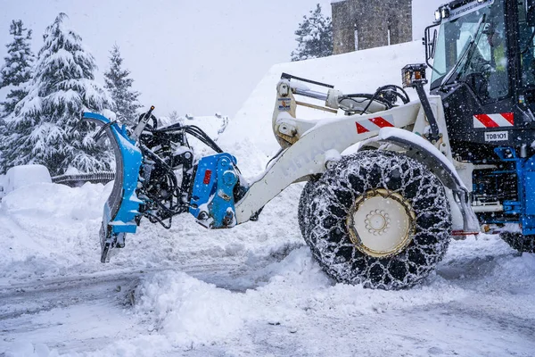 Auron, Fransa 01.01.2021 Traktör Fransız Alpleri 'ndeki kayak merkezinin yanındaki yoldaki büyük kar yığınlarından karı kaldırıyor. — Stok fotoğraf