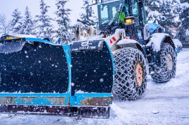 Auron, Fransa 01.01.2021 Traktör Fransız Alpleri 'ndeki kayak merkezinin yanındaki yoldaki büyük kar yığınlarından kar temizliyor. Yüksek kalite fotoğraf