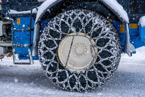 Fransız Alpleri 'ndeki dağ kayak merkezindeki kar küreme aracının zincirlenmiş tekerleğine yakın çekim. — Stok fotoğraf