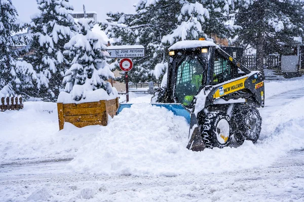 Auron, Fransa 01.01.2021 Tekerlek Yükleme Makinesi kayak merkezindeki karı kaldırıyor. Kardan yolu temizliyorum. — Stok fotoğraf