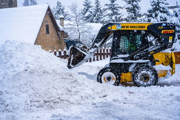 Auron, Fransa 01.01.2021 Tekerlek Yükleme Makinesi kayak merkezindeki karı kaldırıyor. Kardan yolu temizliyorum. — Stok fotoğraf