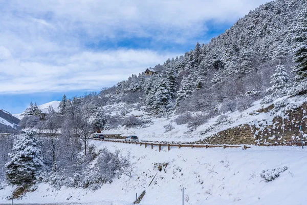 Curva paisaje vial en invierno en los Alpes franceses. Camino de asfalto con los lados llenos de nieve — Foto de Stock