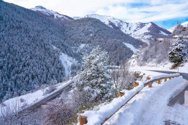 Curva paisaje vial en invierno en los Alpes franceses. Camino de asfalto con los lados llenos de nieve — Foto de Stock