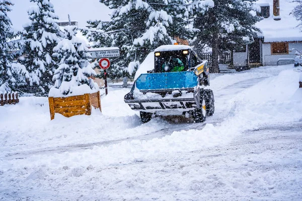 Auron, Fransa - 01.01.2021: Tekerlek yükleme makinesi bir kayak merkezindeki karı temizliyor. Kardan yolu temizliyorum. — Stok fotoğraf
