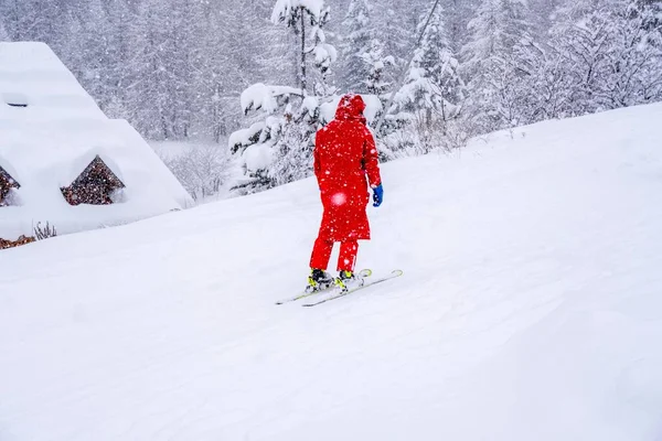 Profesjonalny instruktor narciarski podnoszący linę wyciągową na górę podczas opadów śniegu. Koncepcja aktywnego wypoczynku rodziny i dzieci. Niewyraźne tło ostrości — Zdjęcie stockowe