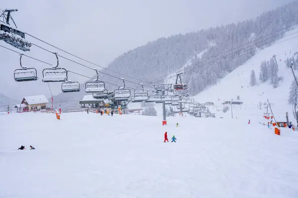 Wintersneeuwdag op een skigebied. Bergafwaarts skiën tijdens een zware sneeuwval. Ski race voor jonge kinderen. wazige scherpstelling — Stockfoto