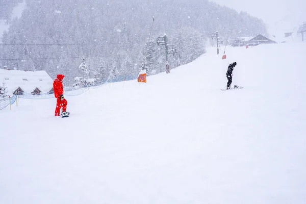 Professionele Instructeur Leert Een Jongen Snowboarden Een Berghelling Sneeuwvaldag Wazige — Stockfoto