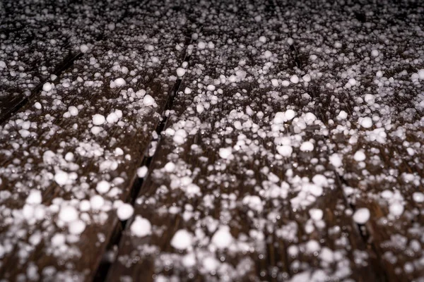 Large grains of hail on a black background. Background, texture. After Heavy Storm with Hail on the terrace in the night.