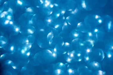 Mavi parıltılı klasik ışık arka planı. Dikkati dağılmış. Yakın plan.