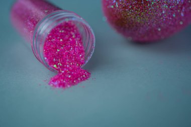 Moda Paskalya arkaplanı, parlak pembe renkli yumurta, mavi ışıklı arka plan ve boş sim tozu şişesi. Paskalya konsepti. Boyalı tavuk yumurtasıyla yaratıcı bir bahar tatili resmi.