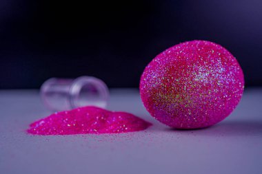 Paskalya arkaplanı, parlak pembe renkli yumurta menekşe ışık arka planında, içi boş sim tozu dolu. Paskalya konsepti. Boyalı tavuk yumurtasıyla yaratıcı bir bahar tatili resmi.