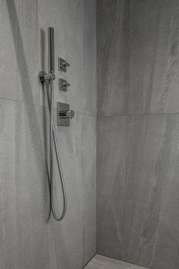  Duvardaki gri mermer arka planda modern krom duş başlığı. Lüks duş kabini. İç ve tasarım için lüks ışık arkaplanı.