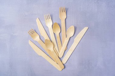 Doğal malzemelerden çevre dostu tek kullanımlık sofra takımı. Doğal gri taş arka planda ahşap çatal bıçak takımı. Üst görünüm kopyalama alanı. Yüksek kalite fotoğraf