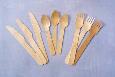 Doğal malzemelerden çevre dostu tek kullanımlık sofra takımı. Doğal gri taş arka planda ahşap çatal bıçak takımı. Üst görünüm kopyalama alanı. Yüksek kalite fotoğraf