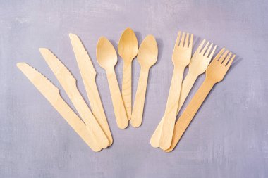 Doğal malzemelerden çevre dostu tek kullanımlık sofra takımı. Doğal gri taş arka planda ahşap çatal bıçak takımı. Üst görünüm kopyalama alanı. Yüksek kalite fotoğraf