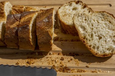 Tahta kesme tahtasının üzerinde ekmek bıçağıyla kesilmiş nefis taze ekmek ekmeği..