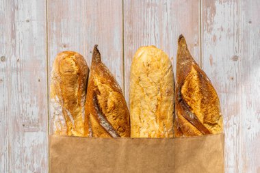 Fransız geleneksel baget ekmeği, tahta masa arkasında kağıt torbalarda. Yüksek kalite fotoğraf