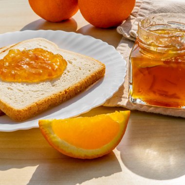 Tahta arka planda kahvaltıda ev yapımı portakal reçelli ekmek dilimleri. Kahvaltı konsepti.
