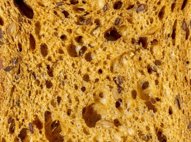 Kahverengi Çavdar Taze Ekmek dilimi. Arkaplan olarak tahıllar, üst manzara. Makro yakın çekim. Yüksek kalite fotoğraf