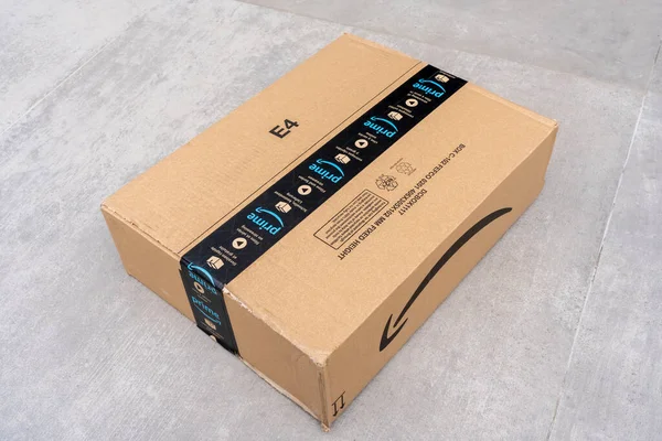 Nice, France- 14.04.2021: Вид зверху на Amazon Prime logotype надрукований на картонній коробці з захисною скотч-стрічкою спереду. Сіре тло — стокове фото